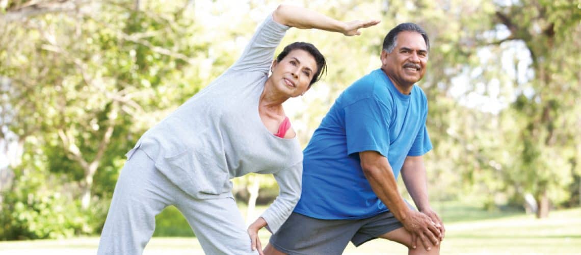 Elderly couple stretching in the park